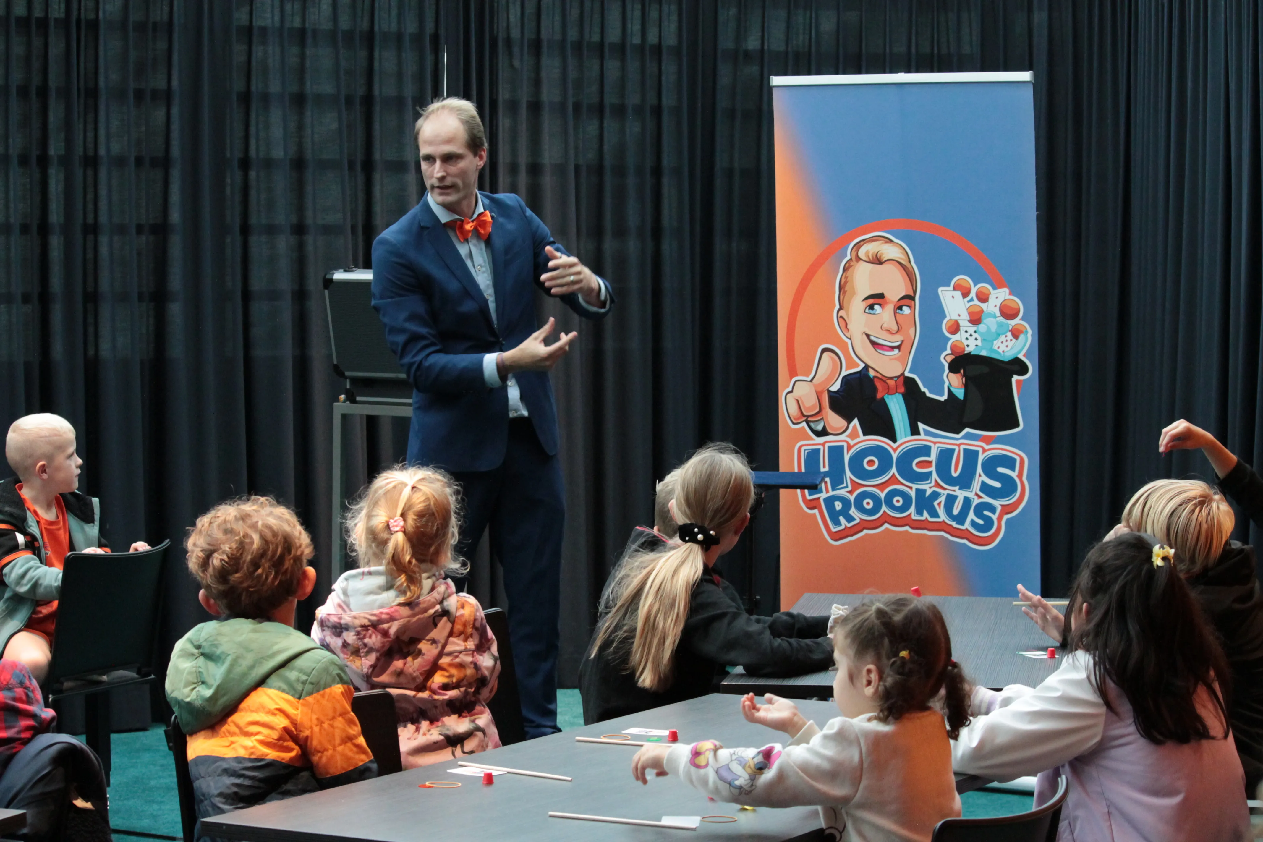 Hocus Rookus goochelt voor kinderen in schoolzaal tijdens kaarttruc