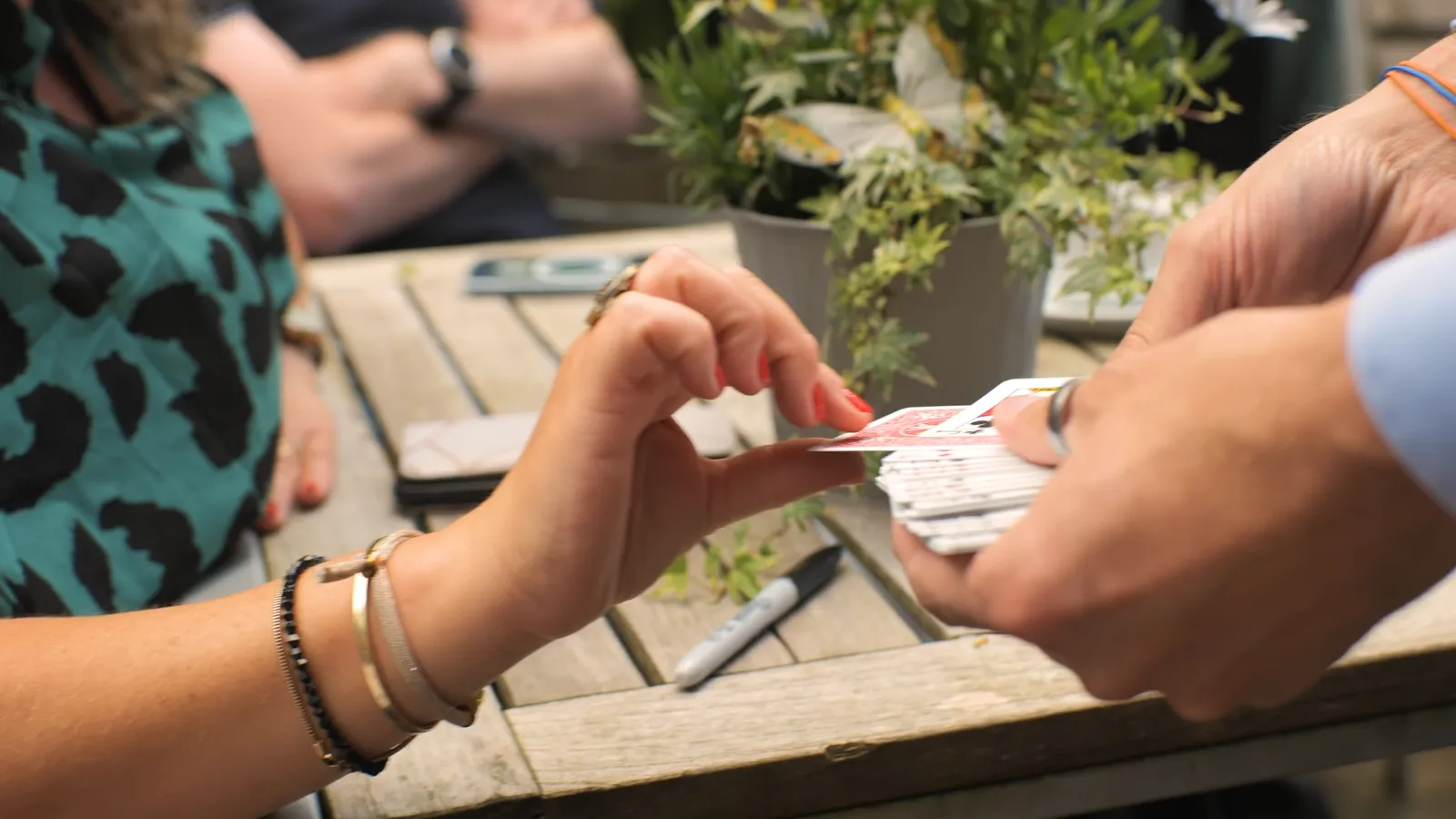 Gast kiest een kaart uit de stapel tijdens close-up magic van Teun Rookus — handen in beeld op tafel