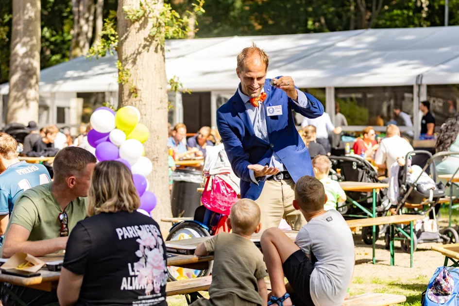 Teun Rookus tussen gasten tijdens een buitenevent — walking magic met kaartdeck