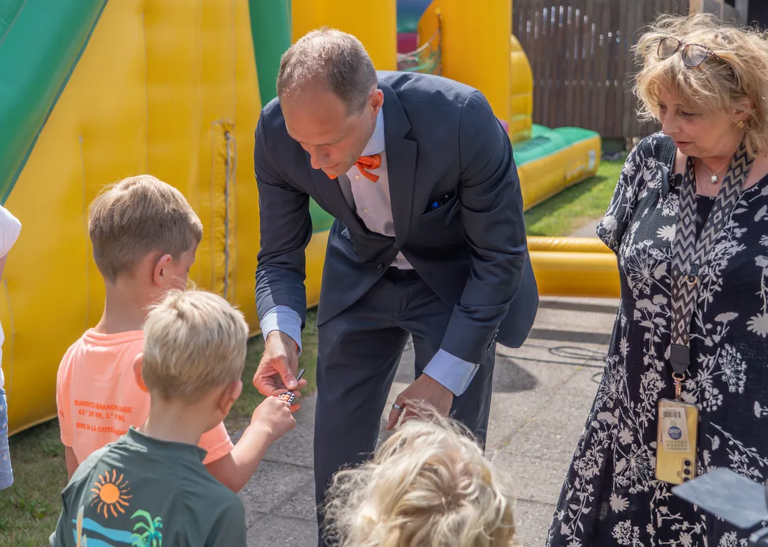 Hocus Rookus toont een close-up truc aan kinderen op de BSO