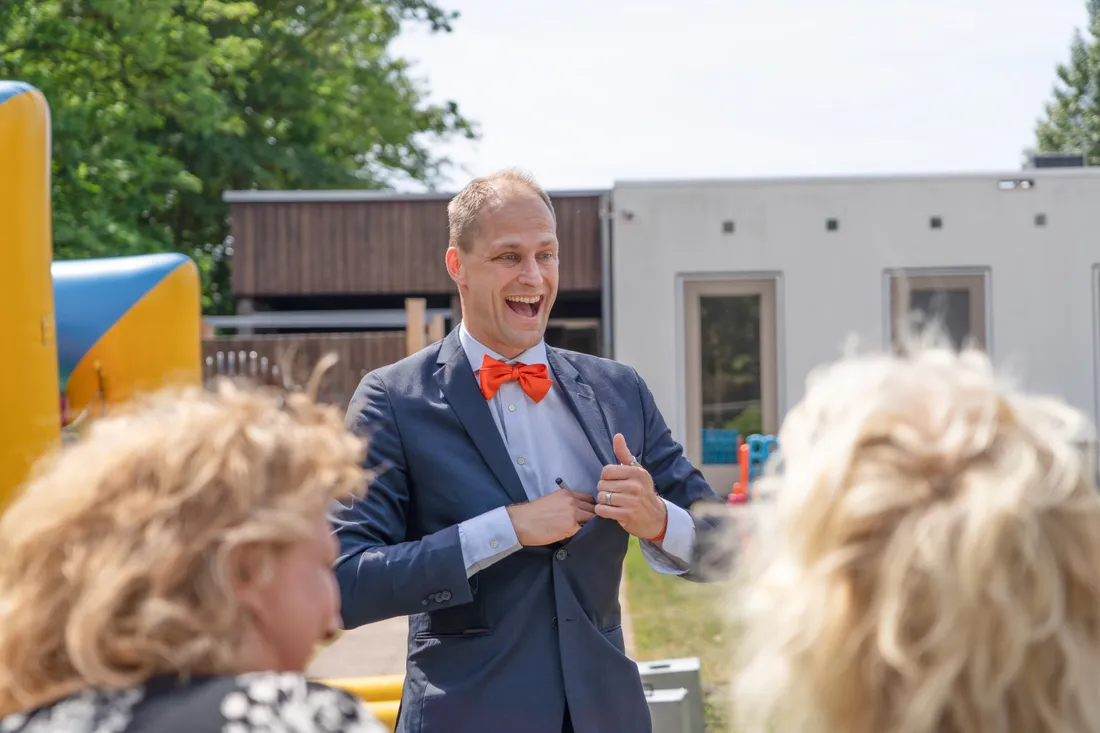 Goochelaar Teun Rookus lacht uitbundig tijdens een interactieve buitenshow